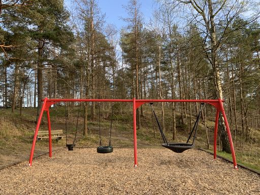 A playground with three different types of swings, adapted for children of different ages.
