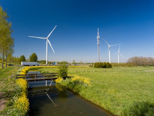 A high angle shot of wind turbines near the highways and meadows captured in the Netherlands