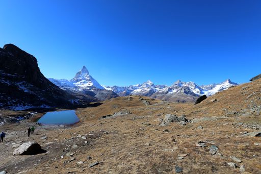 Panoramic autumn view of the Matterhorn and surrounding mountains with a small alpine lake near Zermatt, Switzerland.