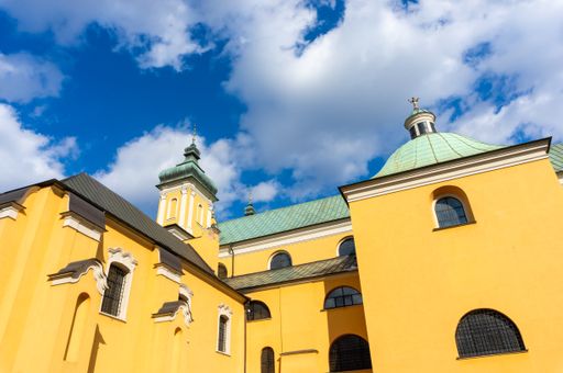 A low angle of an old church building in the city center against a cloudy sky in Poznan, Poland