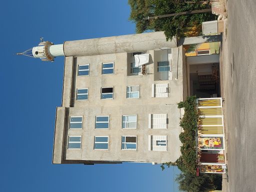 A low-angle shot of a building with a watching tower against the blue sky