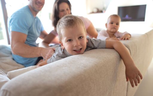 A selective focus shot of a child on the sofa enjoying his quarantine time with family