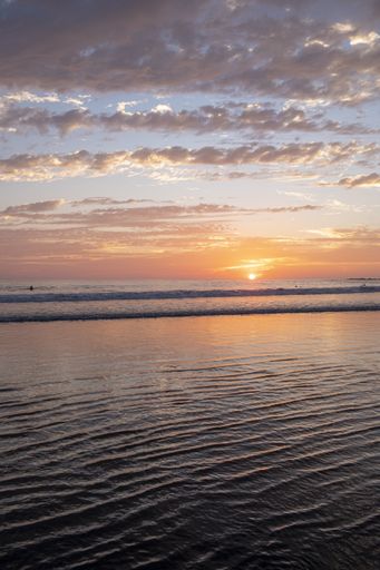 A vertical image of a beautiful orange sunset over the ocean