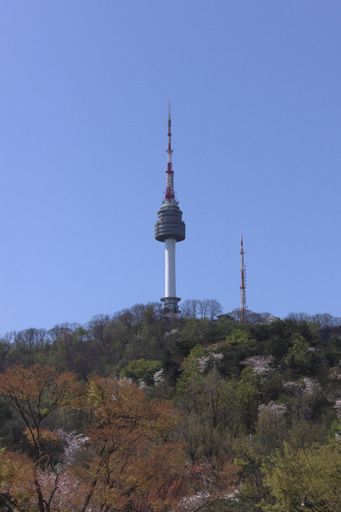 A vertical shot of a Seoul TV tower on Namsan mountain under a clear sky in Korea