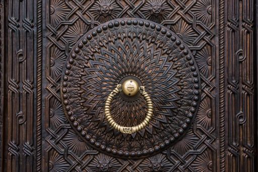 A closeup of a vintage old metal door with knocker