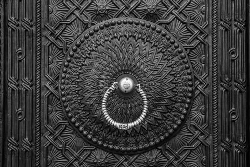 A closeup of a vintage old metal door with knocker