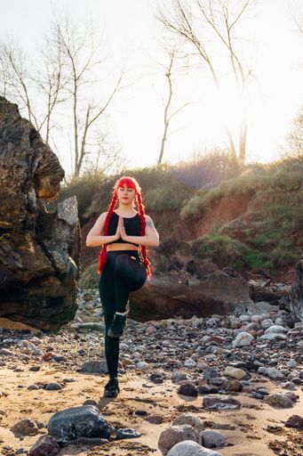 An amazing shot of a young red-haired female doing yoga exercises
