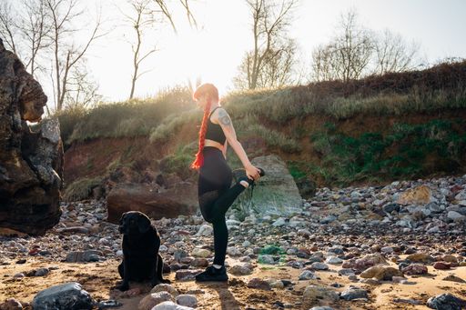 A woman with red hair doing outdoors yoga