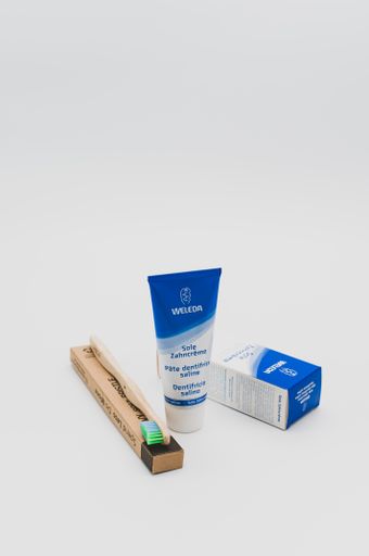 saline tooth paste with environmental friendly natural wood tooth brush with recyclable cardboard box on a white tabletop