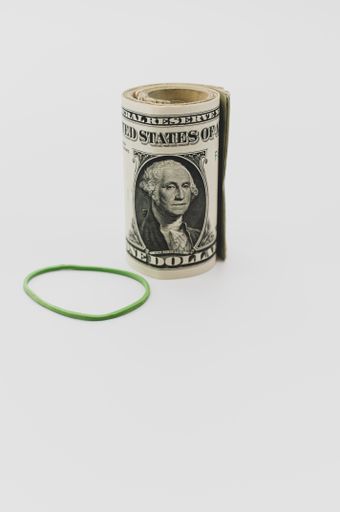 US dollar banknotes rolled up on a white tabletop with text space