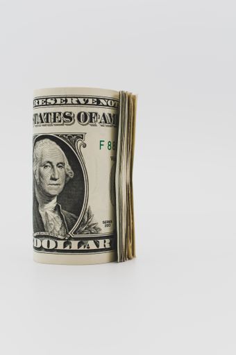 US dollar banknotes rolled up on a white tabletop with text space