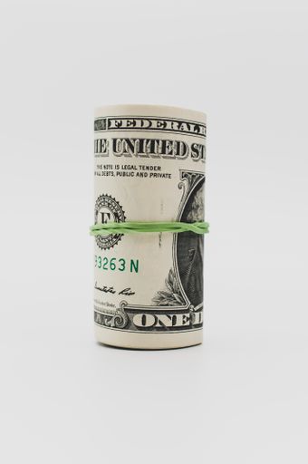 US dollar banknotes rolled up on a white tabletop with text space