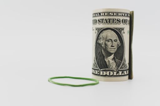 US dollar banknotes rolled up on a white tabletop with text space