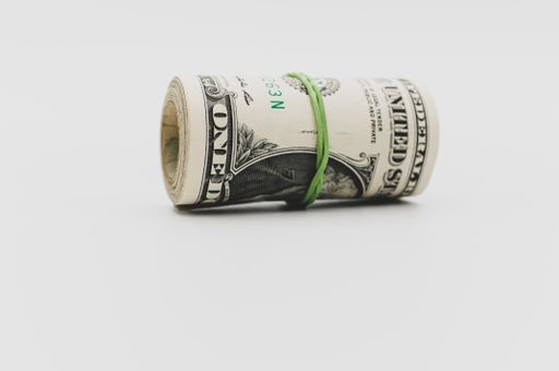 US dollar banknotes rolled up on a white tabletop with text space