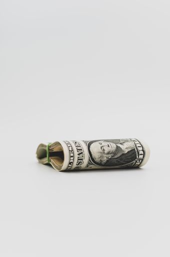 US dollar banknotes wad on a white tabletop with text space