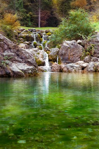 A vertical shot of a small waterfall during the day