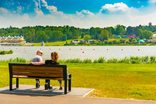 A romantic couple having a good time sitting on the bench in the park in Poznan City