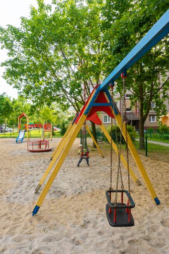 A vertical shot of a swing at a playground in the Stare Zegrze district, Poland