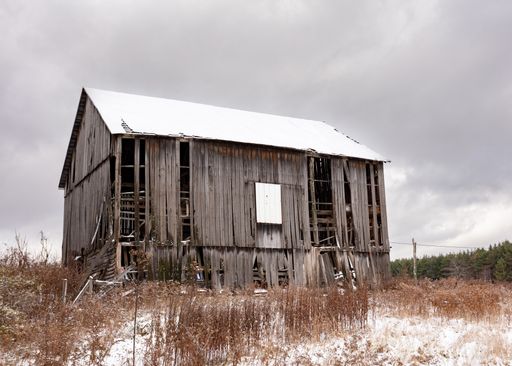An old abandoned wooden barn in a field