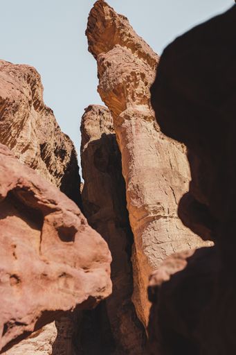 A vertical low angle shot of the beautiful rocky cliffs on the desert captured on a sunny day