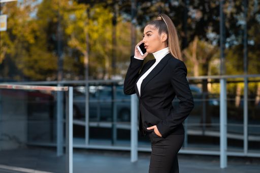 A Caucasian model with an elegant business suit talking on a mobile phone