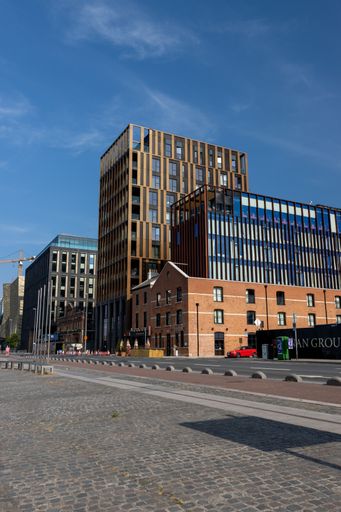 A vertical shot of new apartments and offices built in the Dublin docklands district on a sunny day