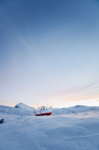 A beautiful view of a small boat on the snow in the North-South under a clear sky