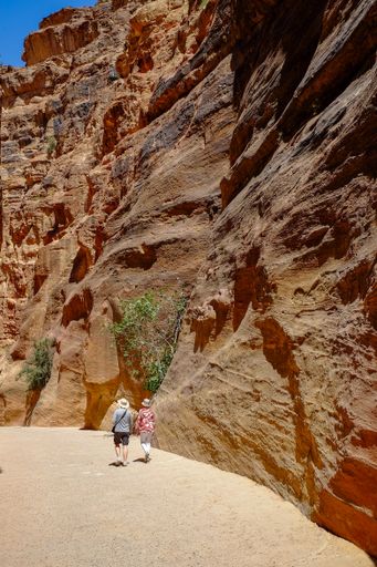 A vertical shot of a couple of tourists in Petra, Jordan