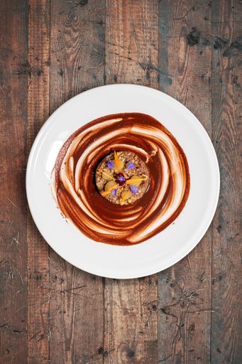 A vertical closeup shot of a delicious vegan dessert with beautiful presentation on a white plate