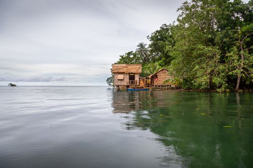 Traditional thatched house over the waters of Lau Lagoon, on the eastern coast of Malaita Province in the Solomon Islands.