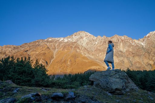 A Caucasian woman looking at the Caucasus mountains in autumn
