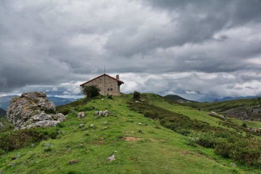 An old stone house on a hill under a gloomy sky in Asturias, Spain