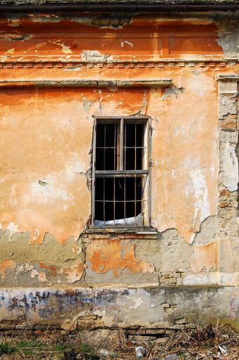 An old wooden window with lattice on the wall of an old house in Hajducica, Banat