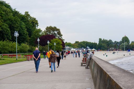 The people walking on the pathway on the side of the beach in Gdynia City