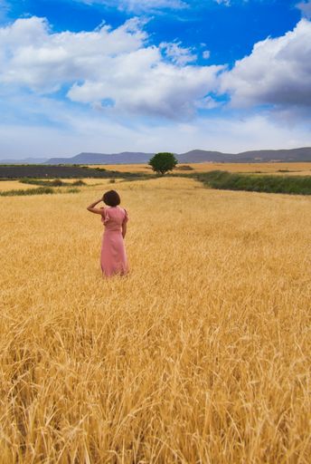 A closeup of a woman posing in a wheat field