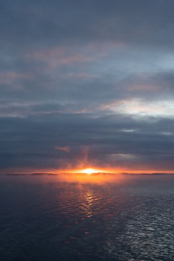 Dark gloomy sky and dramatic sunset scene over the peaceful sea
