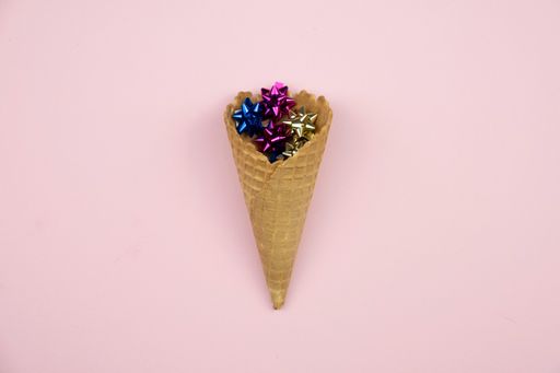 A closeup of an ice cream cone filled with ribbons