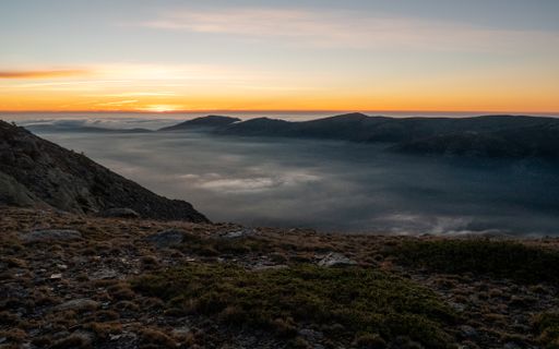 A Breathtaking scene of a sunset from the peaks of mountains and clouds in the sky