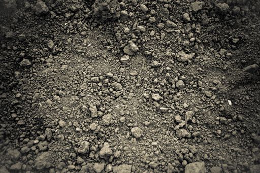 A high angle shot of a land texture with dark sand