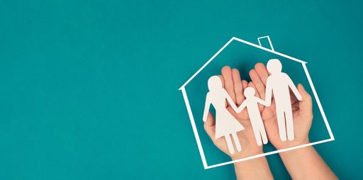 A family, mother, father and child in silhouette, paper cut out, holding in hands, roof of a house, petrol colored background