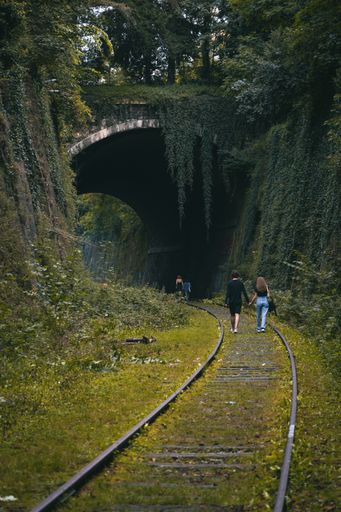 A vertical shot of people walking on a railway