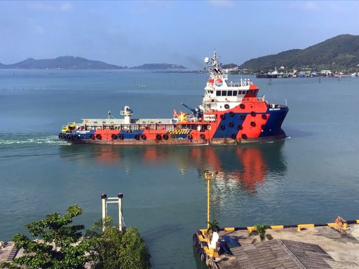 A cargo ship crossing the Songkhla Lake in Thailand under a blue sky on  a sunny da
