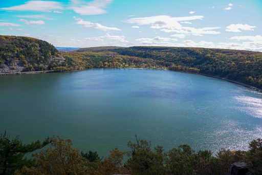 A beautiful view of Devil's Lake surrounded by dense trees and hills in state park Baraboo, Wisconsin
