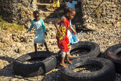 African children playing on car tires in Wasini, Kenya