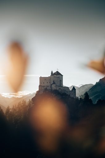 A vertical shot of a castle on a hill in Tarasp, Switzerland captured on a sunny day in the mountains
