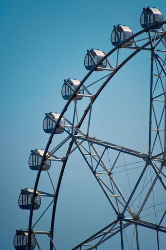 A vertical shot of Ferris wheel quarter cart against a blue sky background