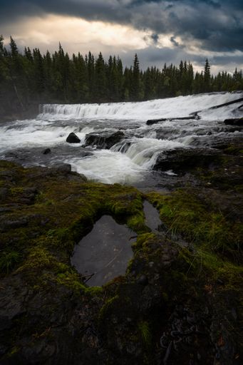 A vertical shot of the Dawson Falls under a stormy sky in Canada