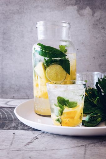 A vertical closeup shot of a glass jar and a drinking glass filled with lemonade juice