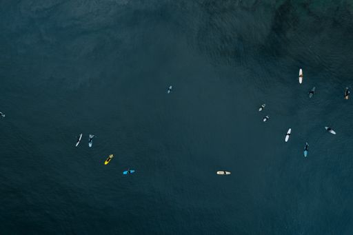 A top view of surfers in blue ocean water