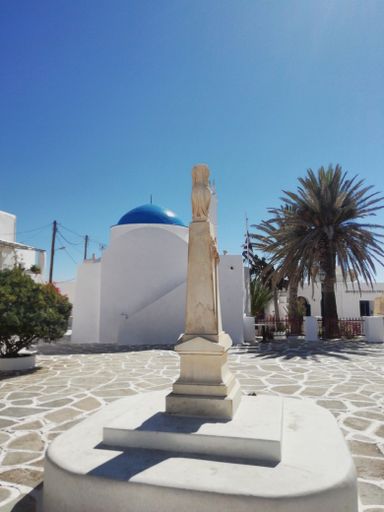 The main square at the beautiful Greek island of Sikinos.  The war memorial stands proudly in front of the islands main church on a summers day.
